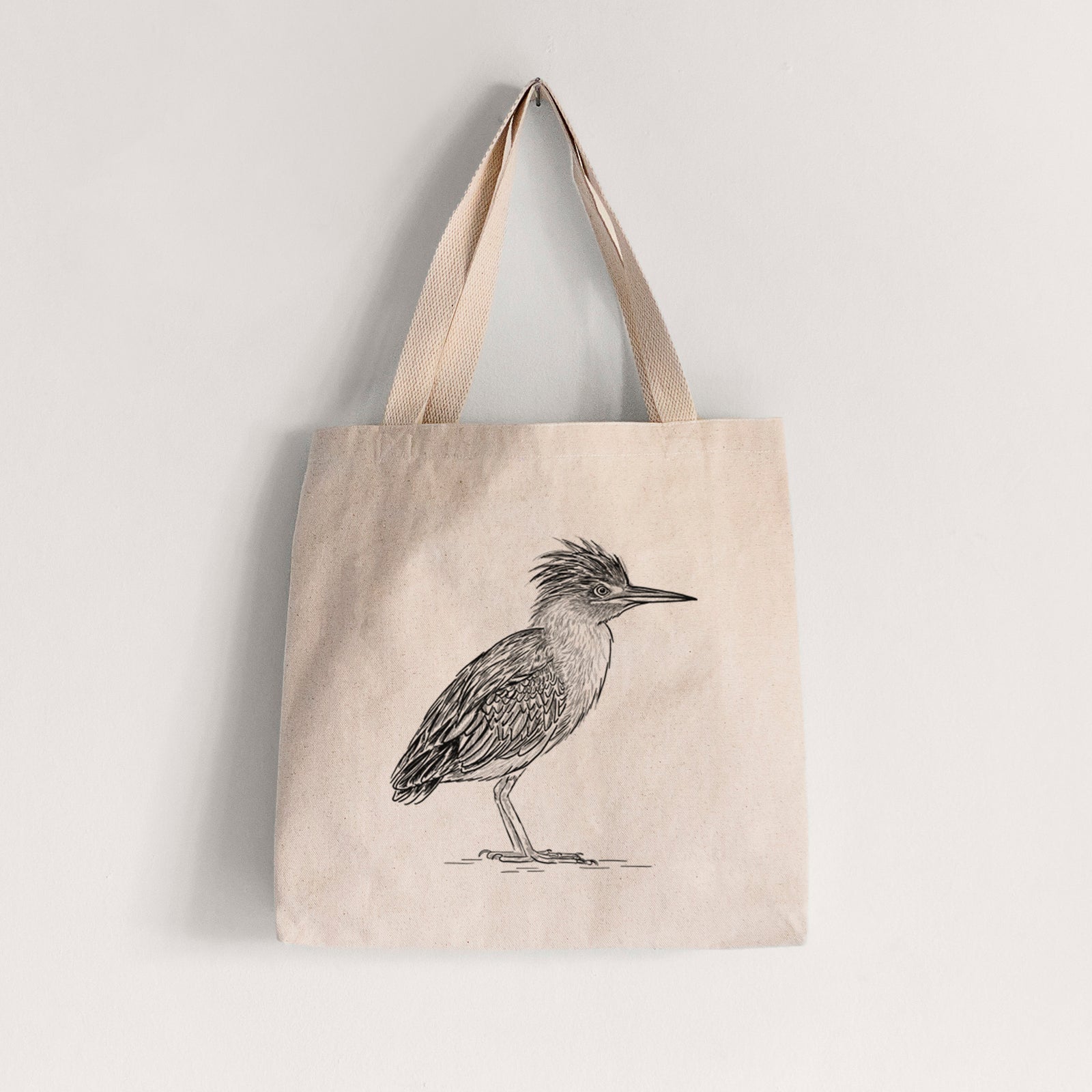 Natural canvas tote bag printed with a detailed black ink illustration of a green heron standing with its crest raised.
