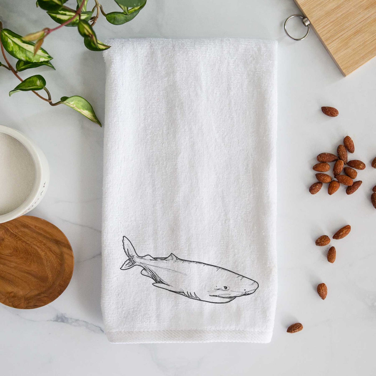 White hand towel printed with a black ink illustration of a Greenland shark swimming.