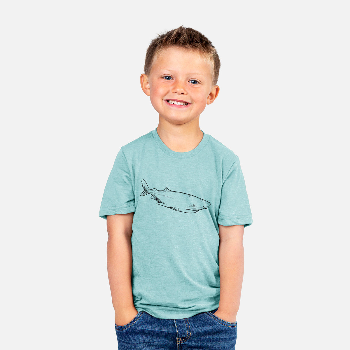 Smiling boy wearing a youth t-shirt printed with a black ink illustration of a Greenland shark swimming.