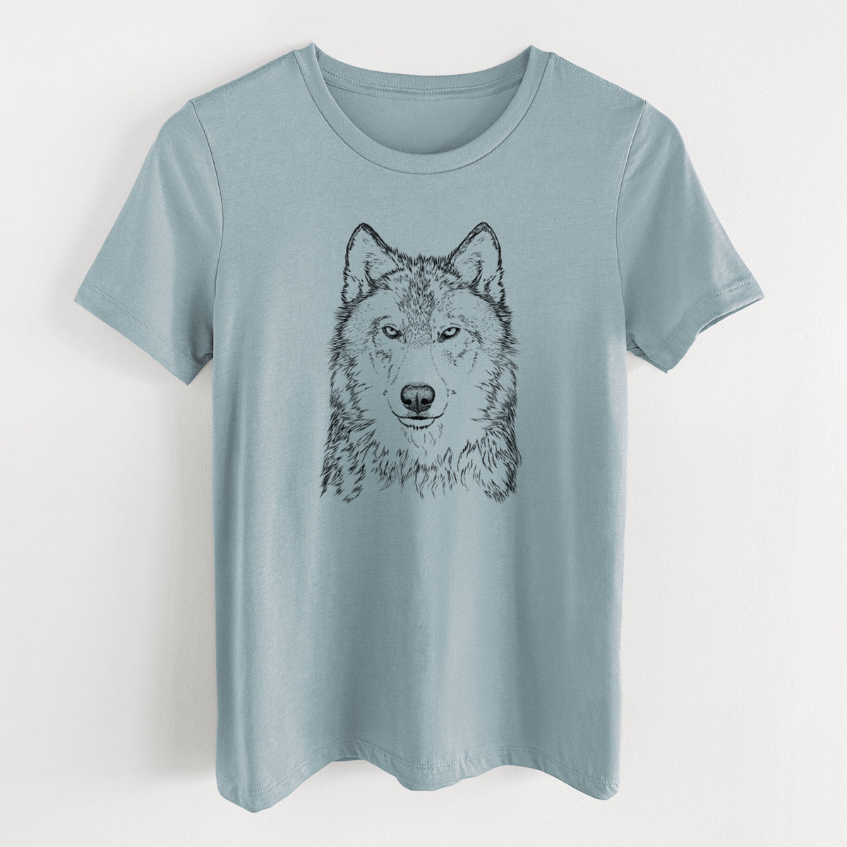 Vintage denim women's relaxed fit cotton t-shirt laid flat, printed with a detailed black ink portrait of a grey wolf facing forward.