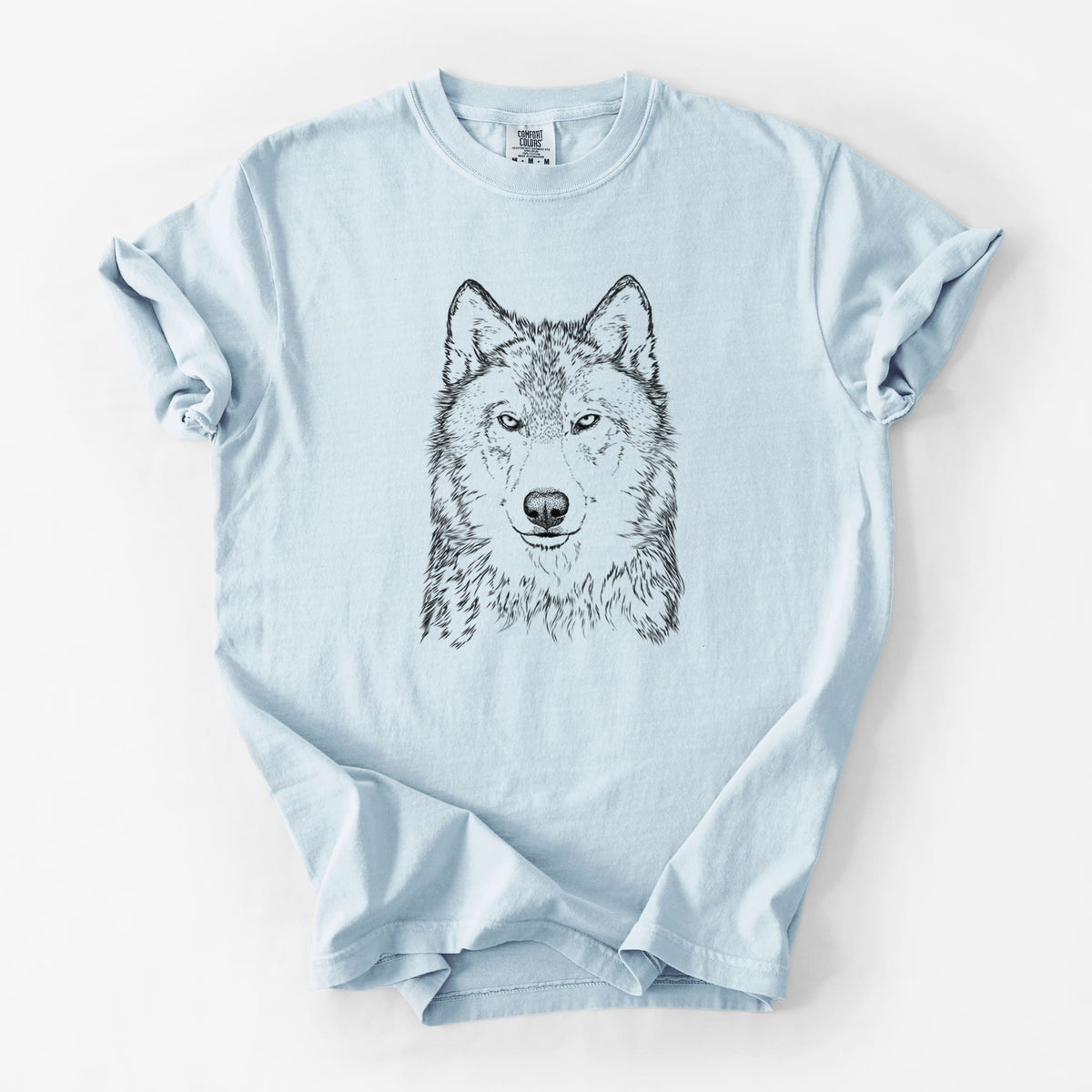 Chambray blue Comfort Colors t-shirt laid flat, printed with a detailed black ink portrait of a grey wolf facing forward.