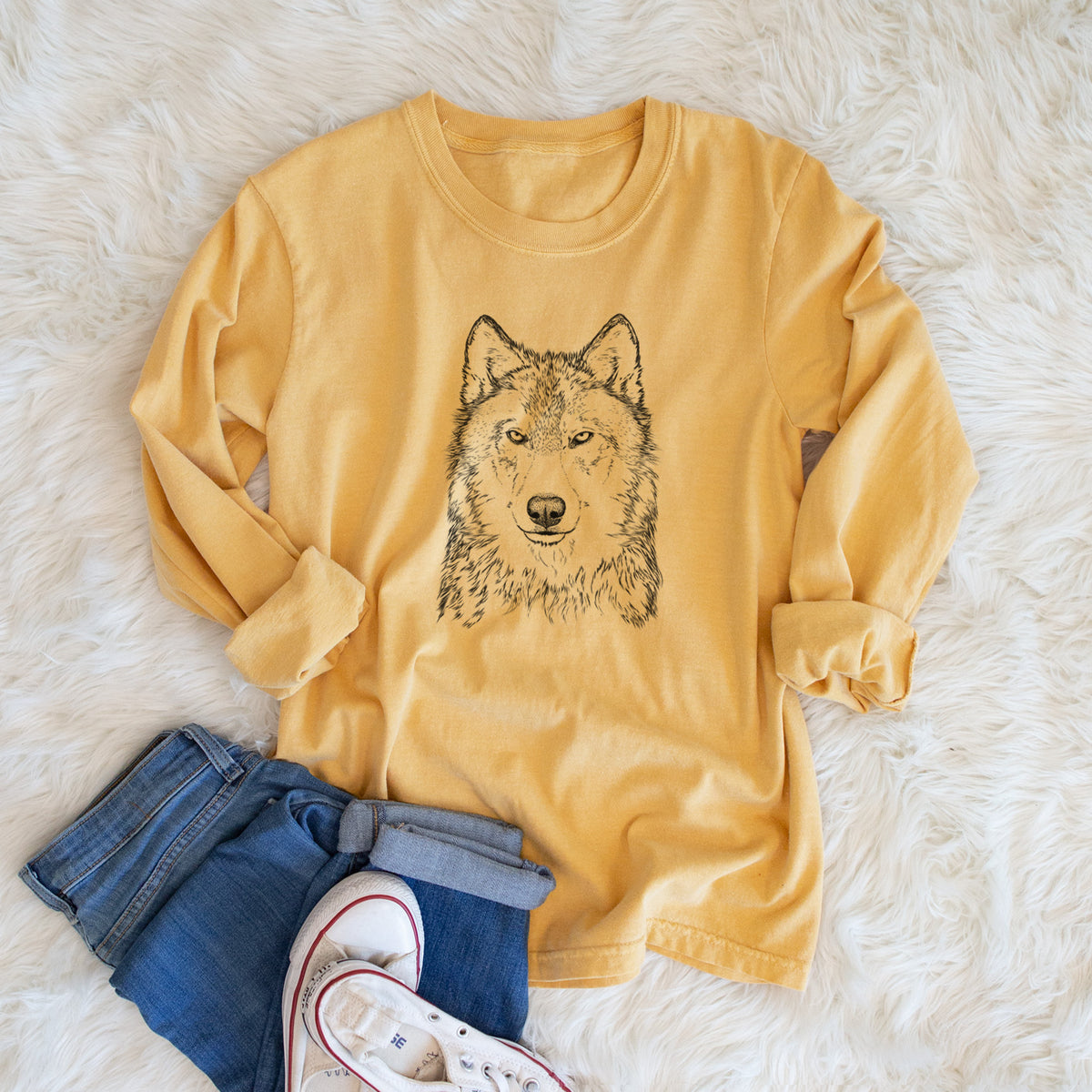 Golden wheat yellow Comfort Colors long sleeve shirt printed with a detailed black ink portrait of a grey wolf facing forward, shown in a lifestyle photo.