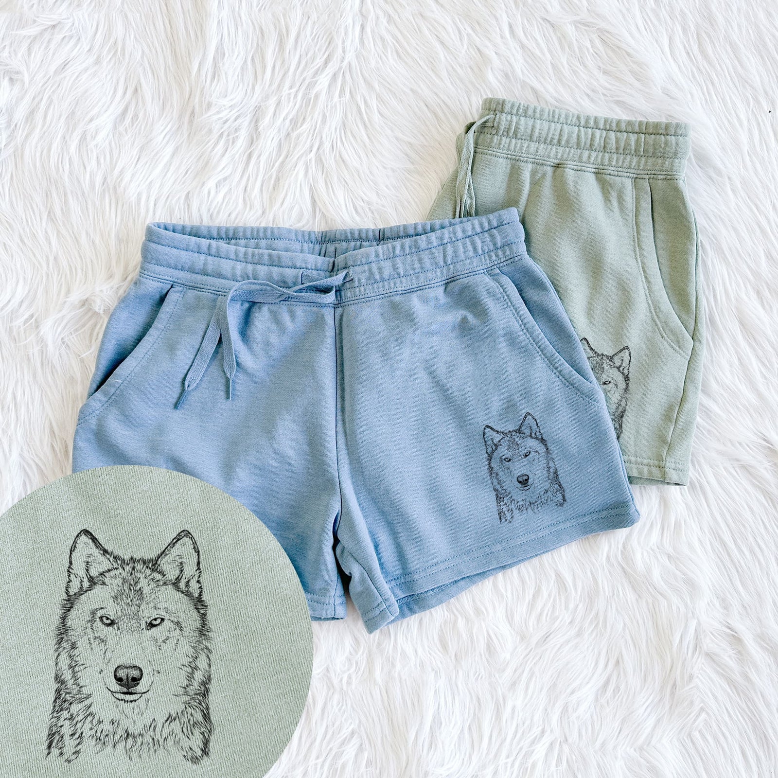 Two pairs of Cali Wave shorts in different colors printed with a detailed black ink portrait of a grey wolf facing forward, with a close-up of the print.