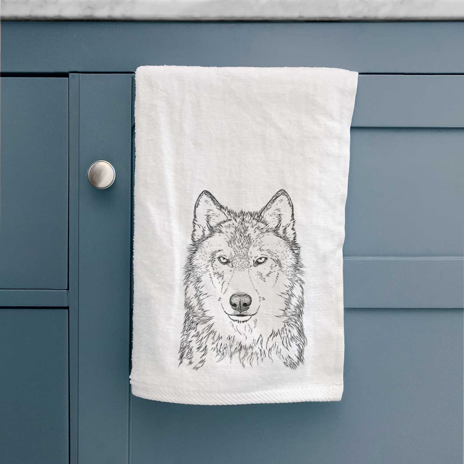 White hand towel printed with a detailed black ink portrait of a grey wolf facing forward.