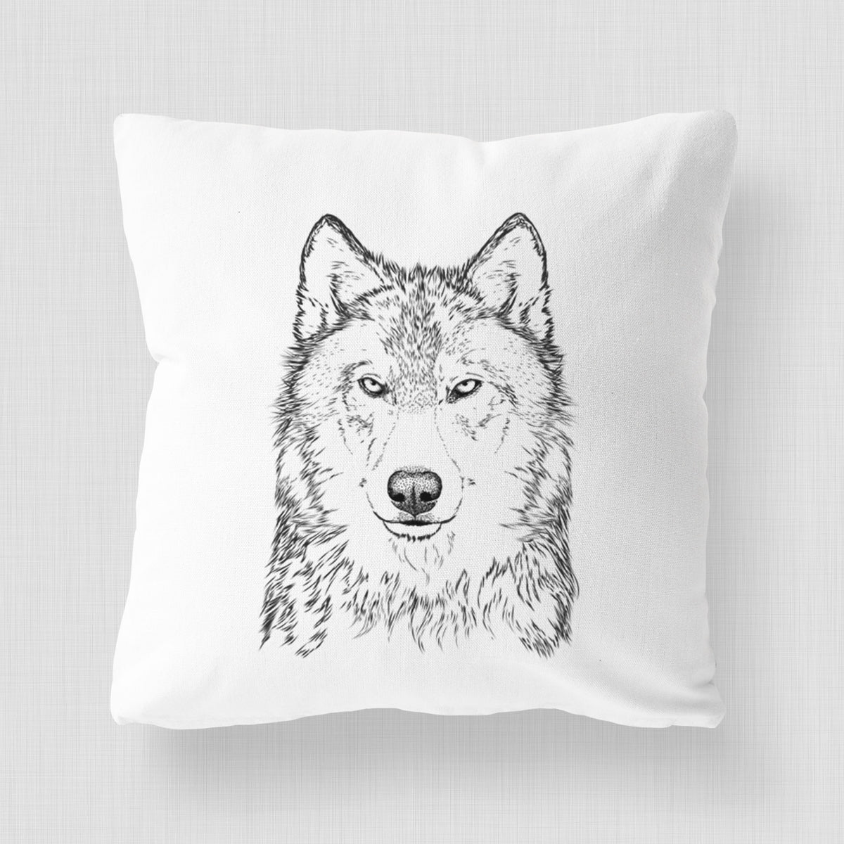 White pillow cover printed with a detailed black ink portrait of a grey wolf facing forward.