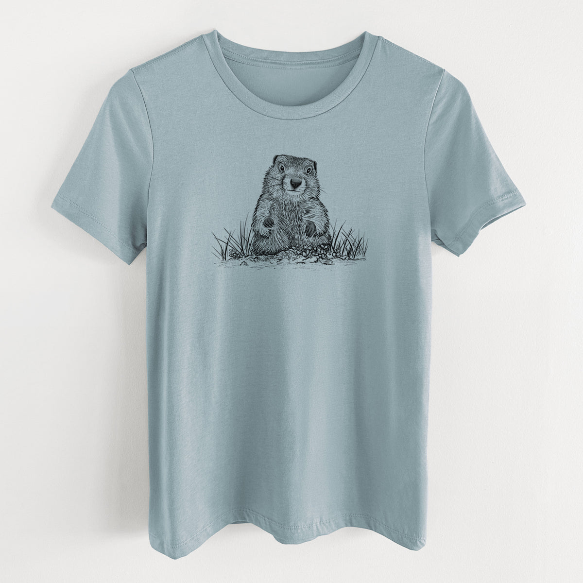 Vintage denim women's relaxed fit cotton t-shirt laid flat, printed with a black ink illustration of a groundhog peeking out of its burrow among grass.
