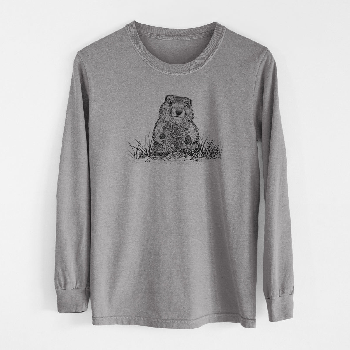 Grey Comfort Colors long sleeve shirt laid flat, printed with a black ink illustration of a groundhog peeking out of its burrow among grass.