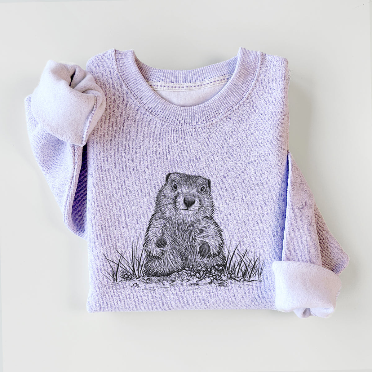Ice purple knit sweatshirt printed with a black ink illustration of a groundhog peeking out of its burrow among grass, styled flat.