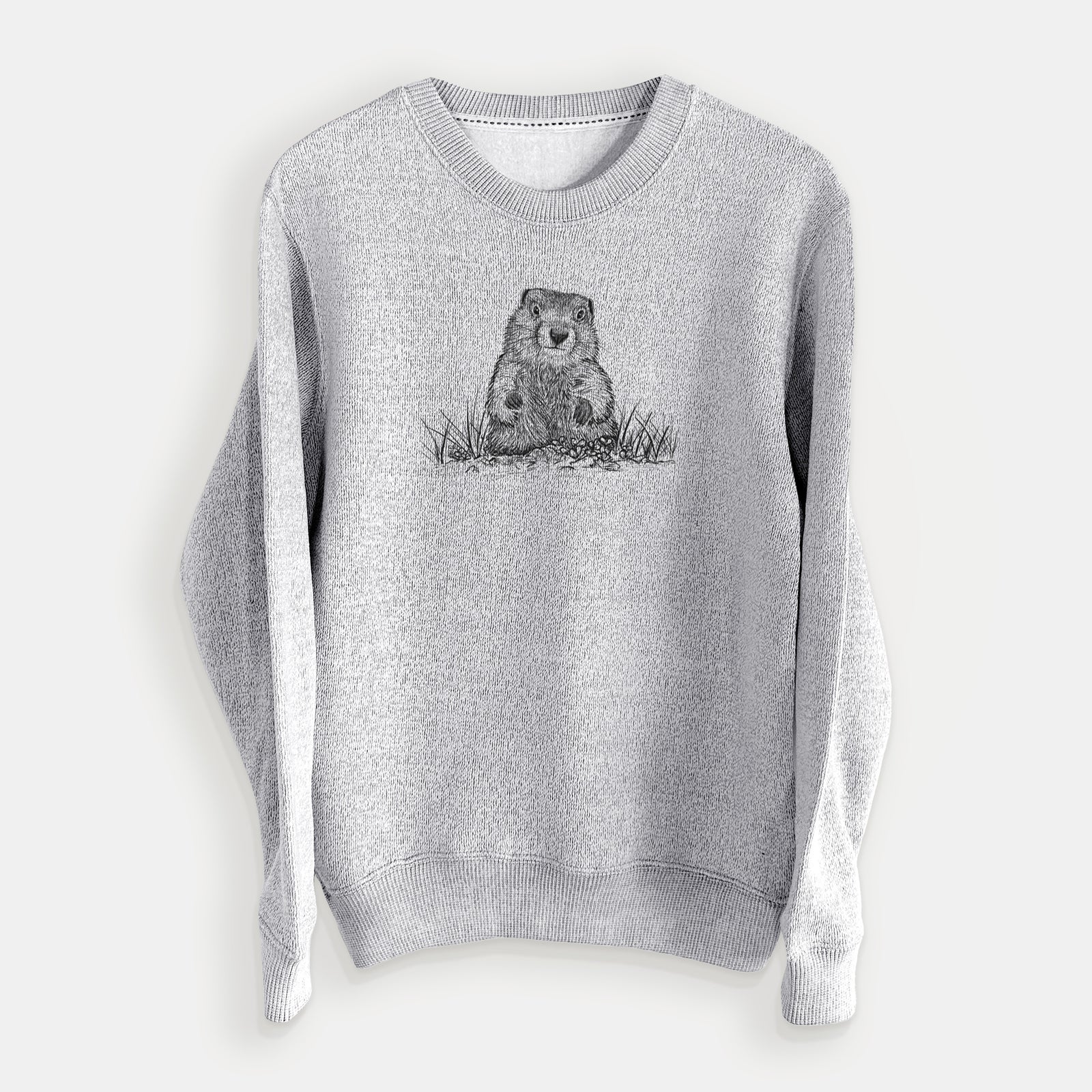 Salt and pepper knit sweatshirt laid flat, printed with a black ink illustration of a groundhog peeking out of its burrow among grass.