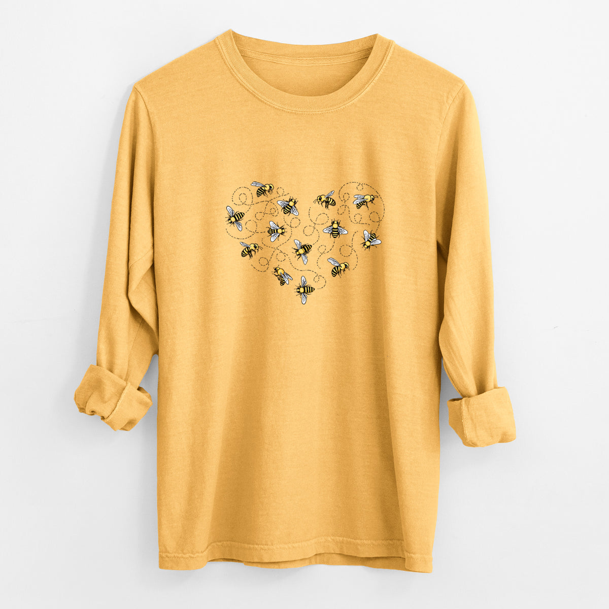 Golden wheat yellow Comfort Colors long sleeve shirt laid flat with the cuffs rolled, printed with a heart shape made of small bees and looping flight trails.