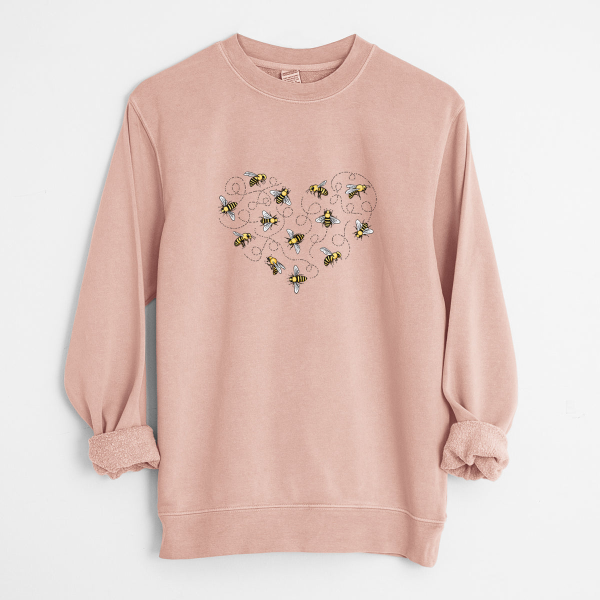 Dusty pink pigment dyed crewneck sweatshirt laid flat with the sleeves rolled, printed with a heart shape made of small bees and looping flight trails.