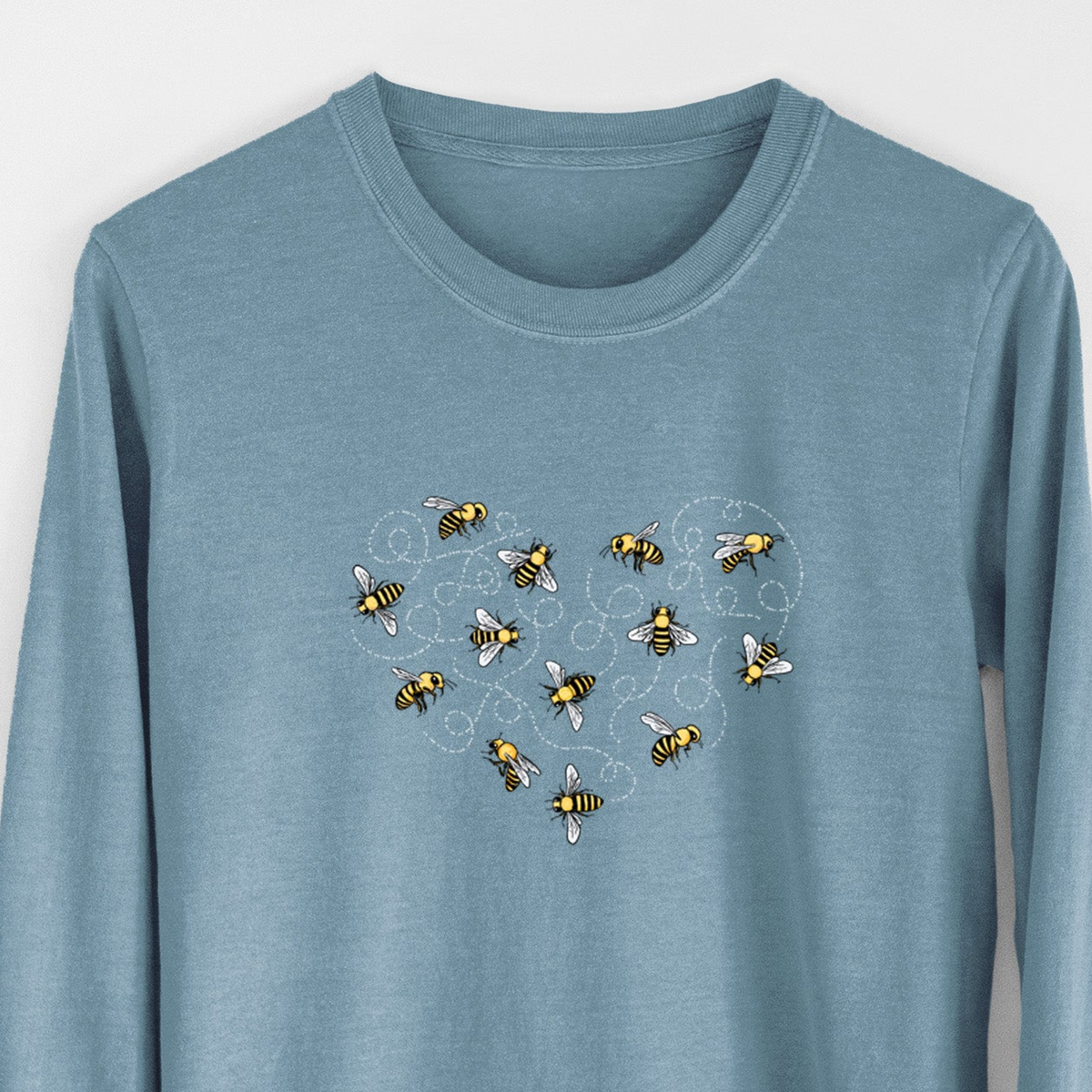 Steel blue Comfort Colors long sleeve shirt laid flat, printed with a heart shape made of small bees and looping flight trails.