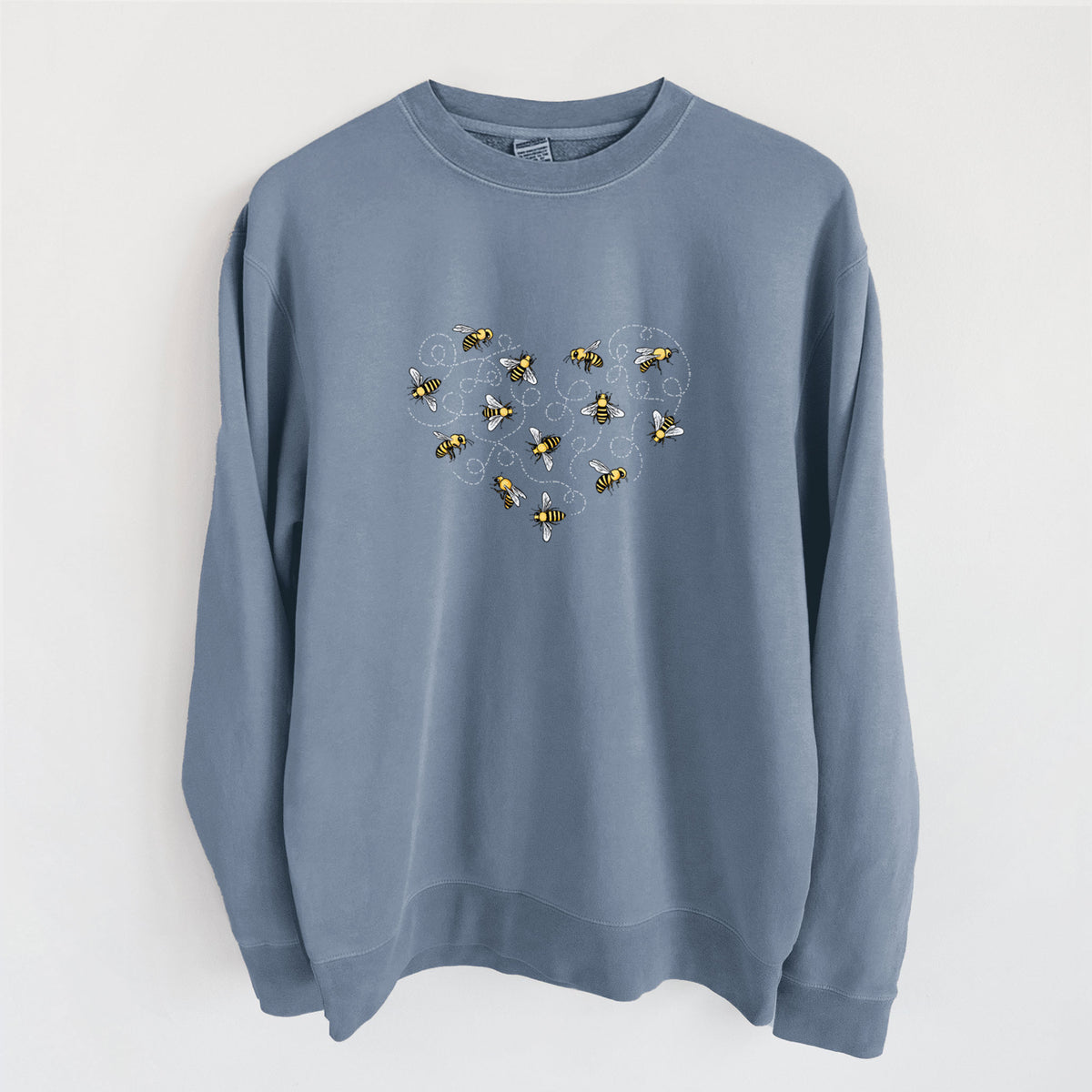 Slate blue pigment dyed crewneck sweatshirt laid flat, printed with a heart shape made of small bees and looping flight trails.