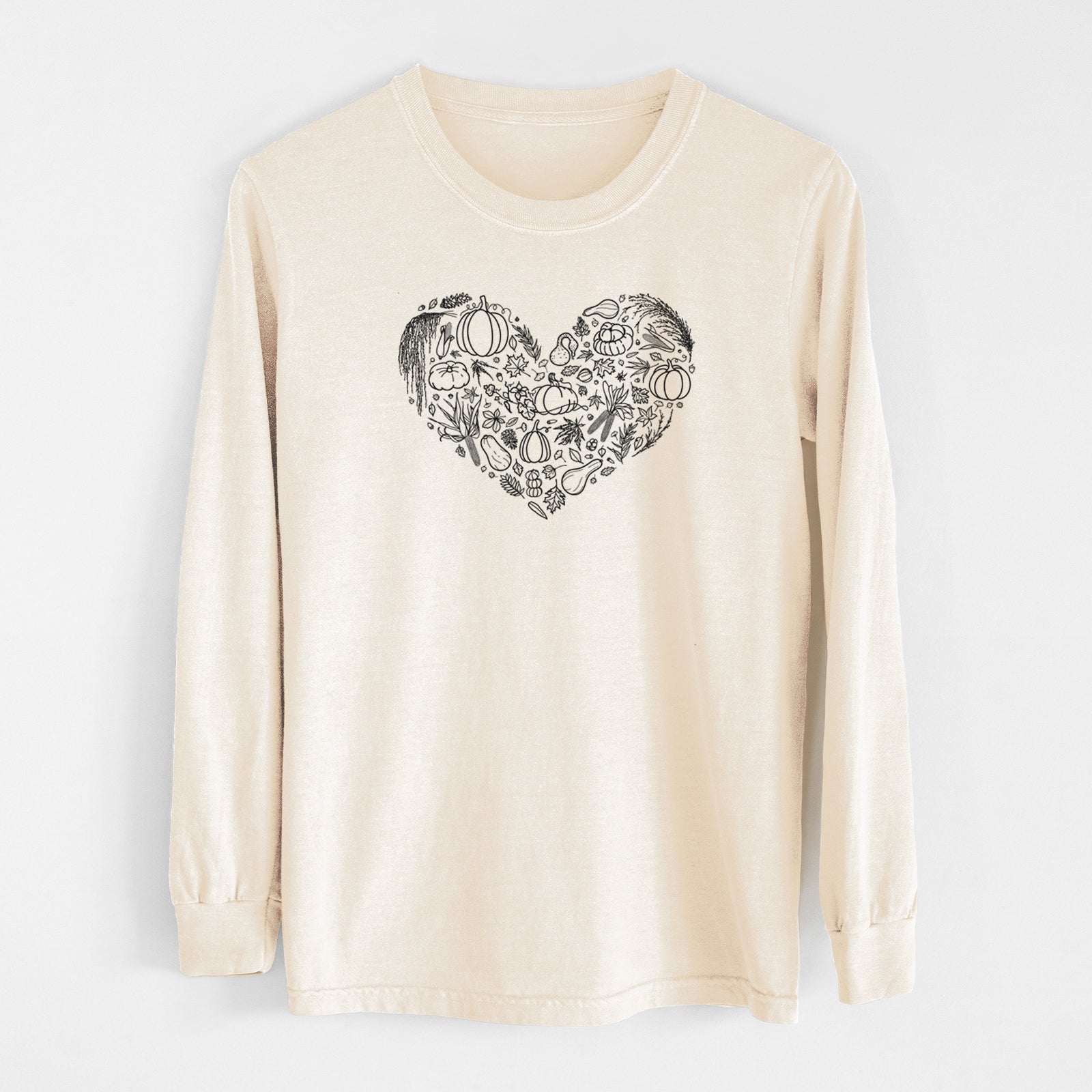 Ivory Comfort Colors long sleeve shirt laid flat, printed with a heart shape filled with black ink autumn leaves, acorns, pumpkins and mushrooms.