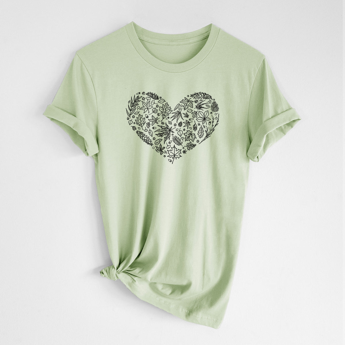 Spring green lightweight cotton t-shirt laid flat with the sleeves rolled, printed with a heart shape filled with black ink autumn leaves.