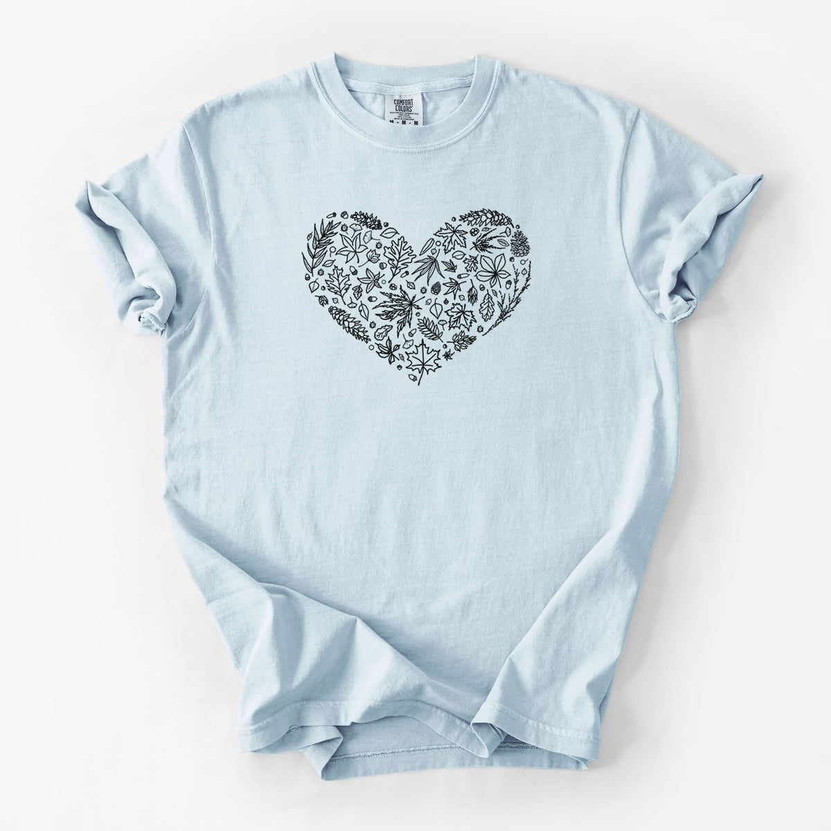 Chambray blue Comfort Colors t-shirt laid flat, printed with a heart shape filled with black ink autumn leaves.