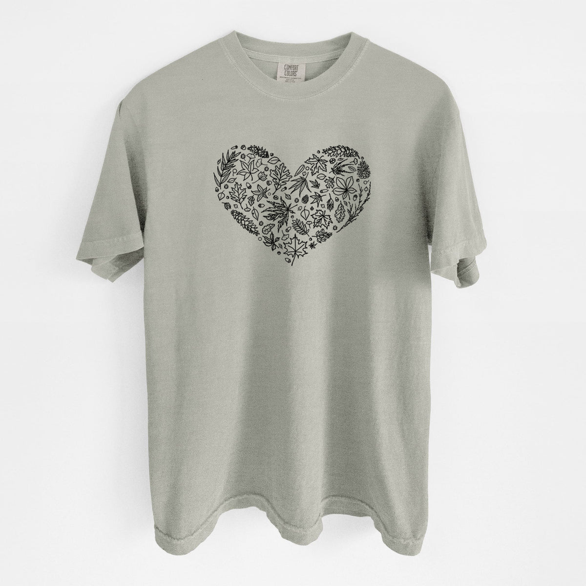 Sandstone beige Comfort Colors t-shirt laid flat, printed with a heart shape filled with black ink autumn leaves.