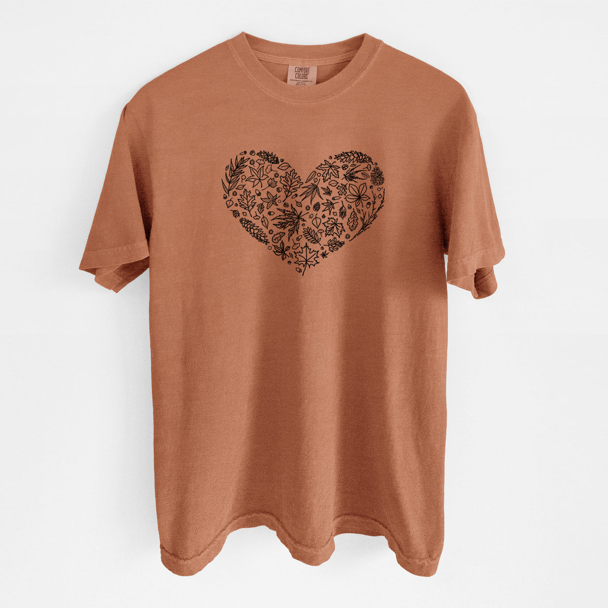 Yam burnt orange Comfort Colors t-shirt laid flat, printed with a heart shape filled with black ink autumn leaves.