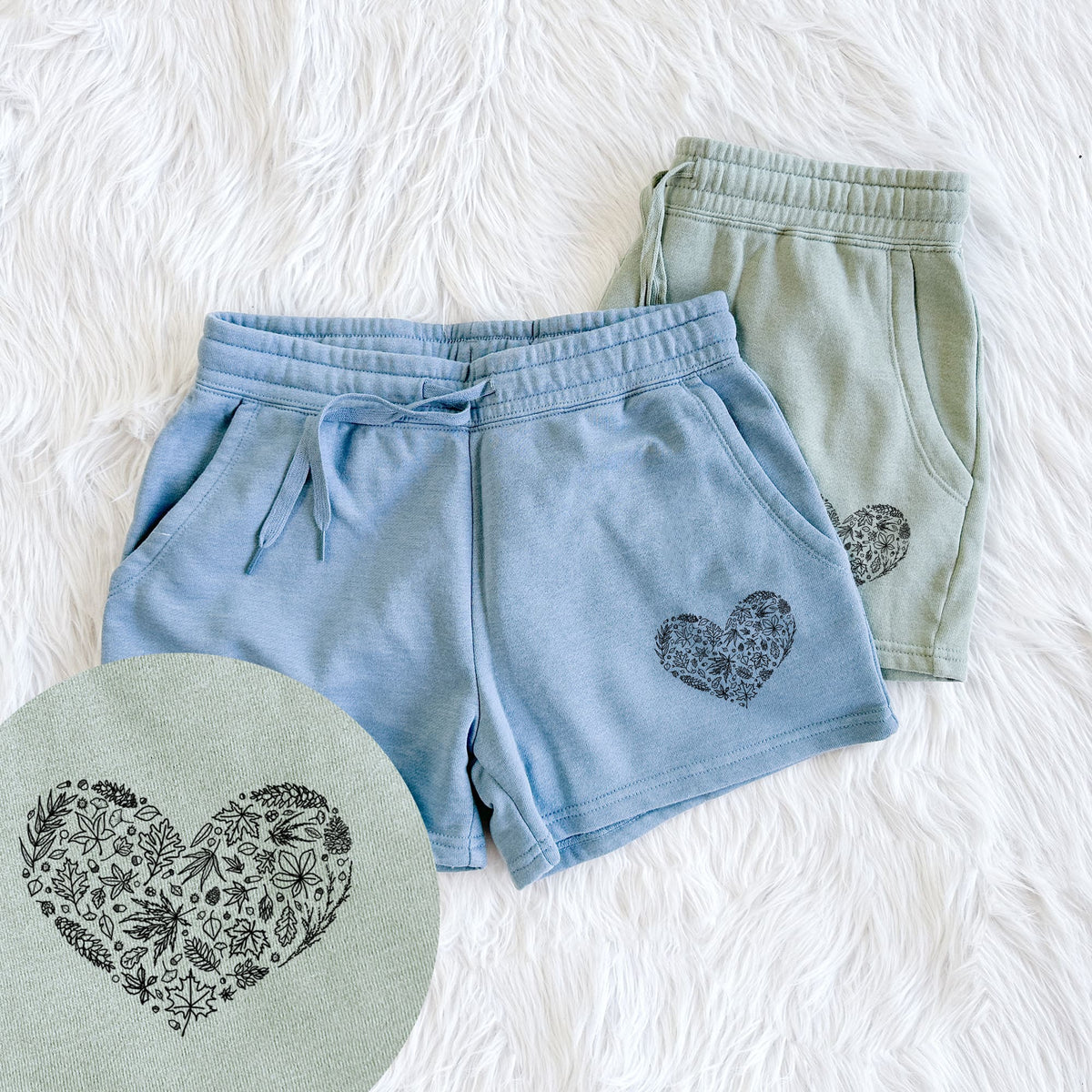 Two pairs of Cali Wave shorts in different colors printed with a heart shape filled with black ink autumn leaves, with a close-up of the print.