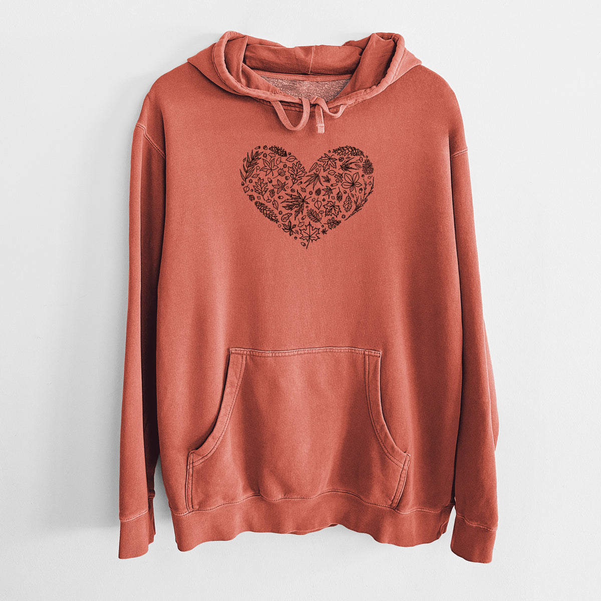 Amber orange pigment dyed hoodie laid flat, printed with a heart shape filled with black ink autumn leaves.