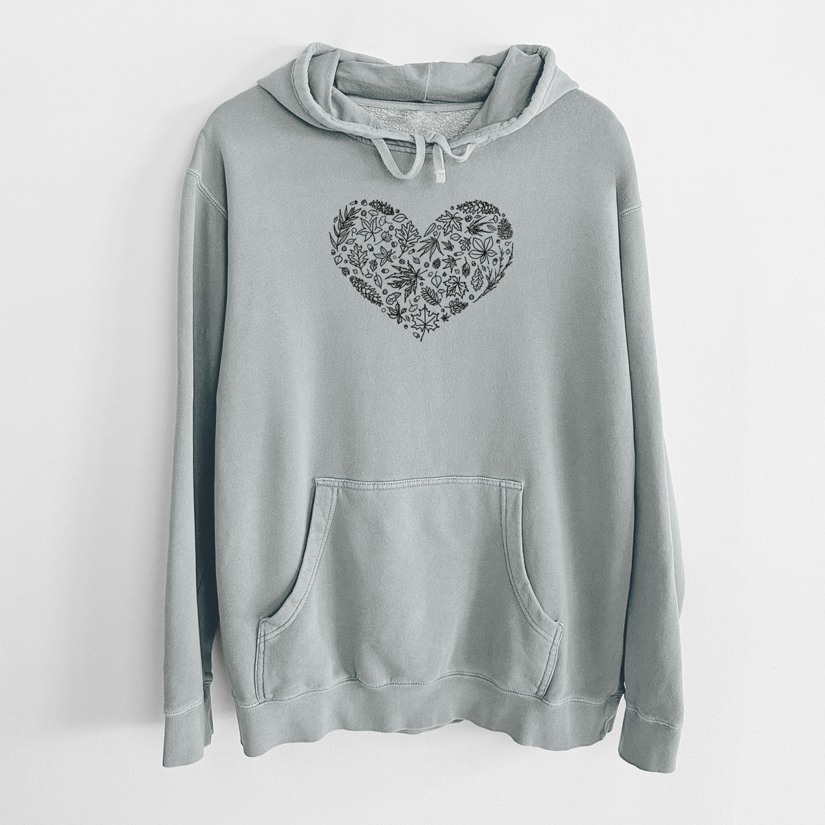 Sage green pigment dyed hoodie laid flat, printed with a heart shape filled with black ink autumn leaves.