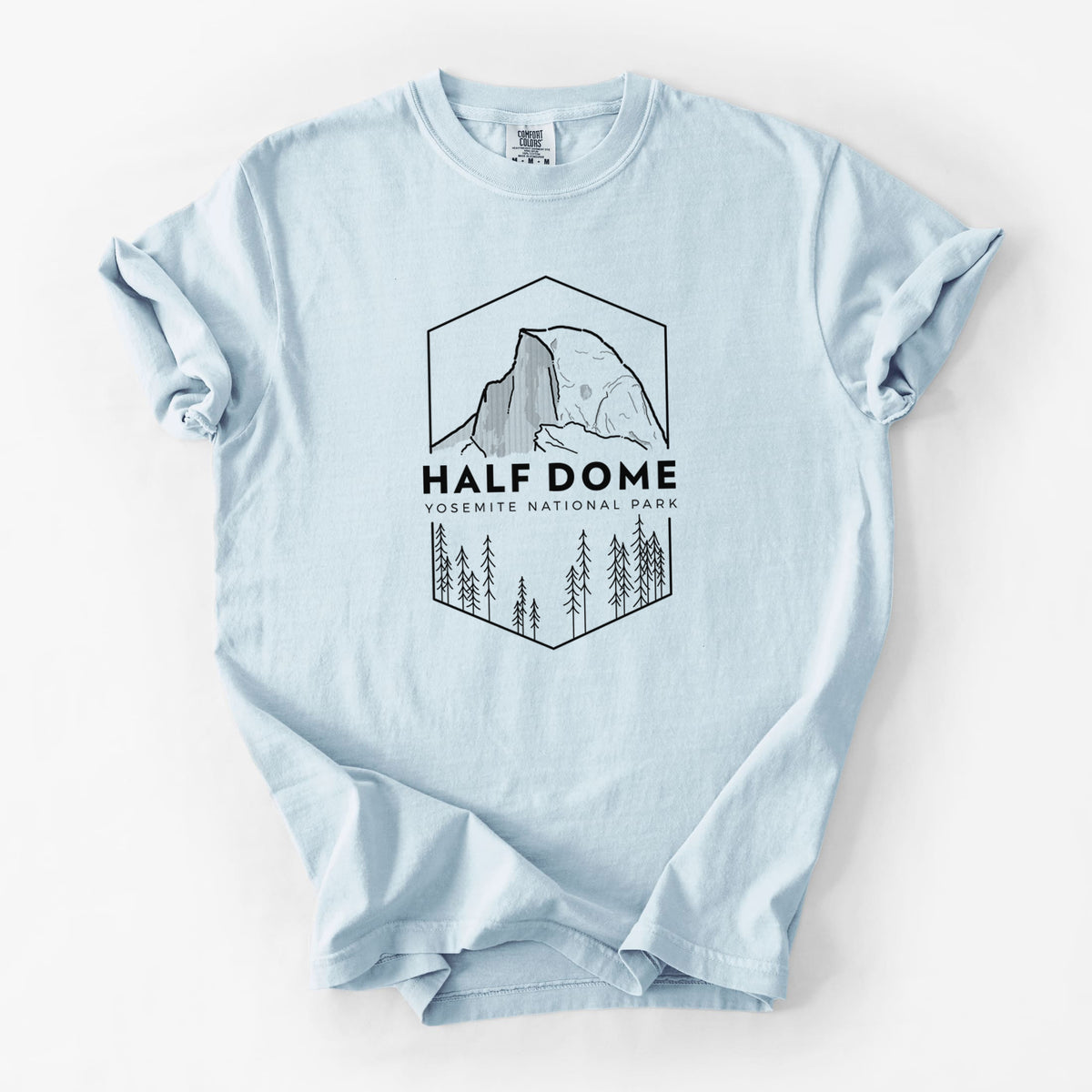 Chambray blue Comfort Colors t-shirt laid flat, printed with a black line art badge of Half Dome above a pine forest, with the words Half Dome, Yosemite National Park.