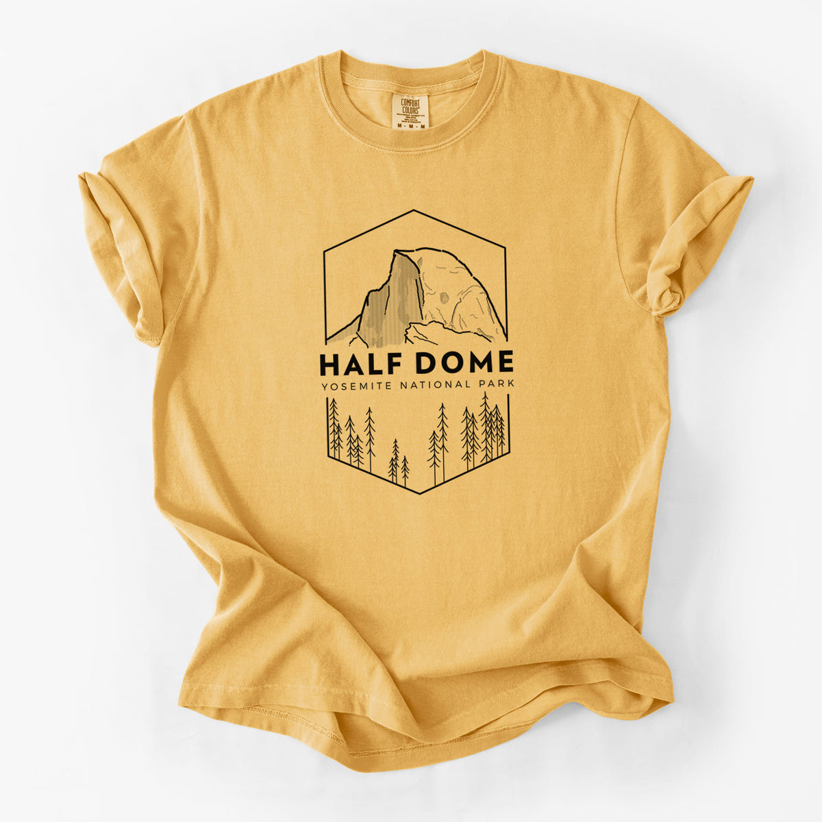 Golden wheat yellow Comfort Colors t-shirt laid flat, printed with a black line art badge of Half Dome above a pine forest, with the words Half Dome, Yosemite National Park.