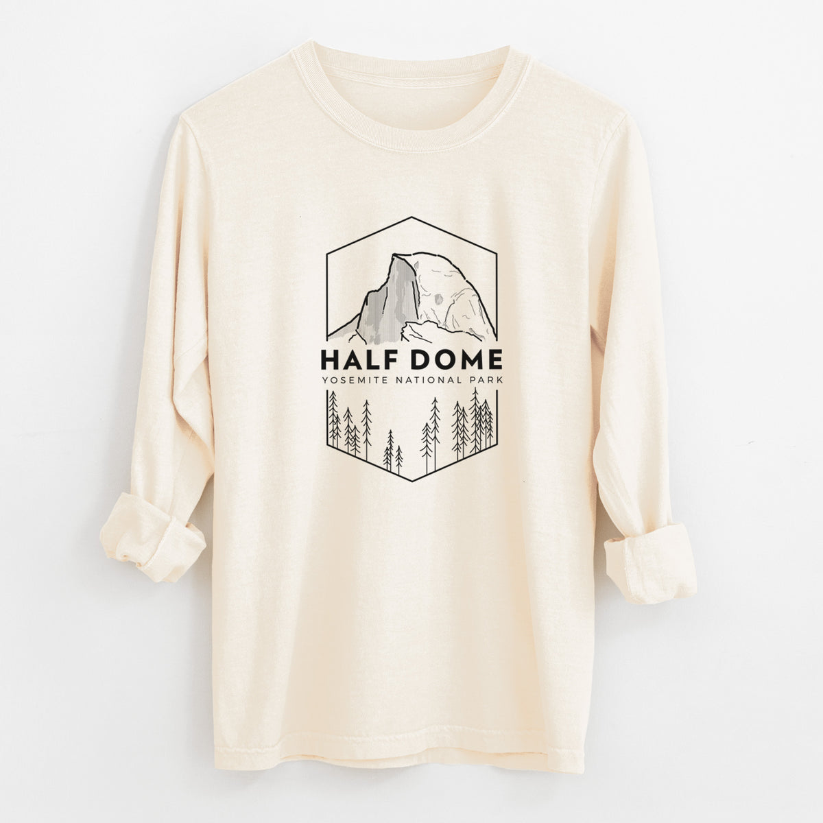 Ivory Comfort Colors long sleeve shirt laid flat with the cuffs rolled, printed with a black line art badge of Half Dome above a pine forest, with the words Half Dome, Yosemite National Park.