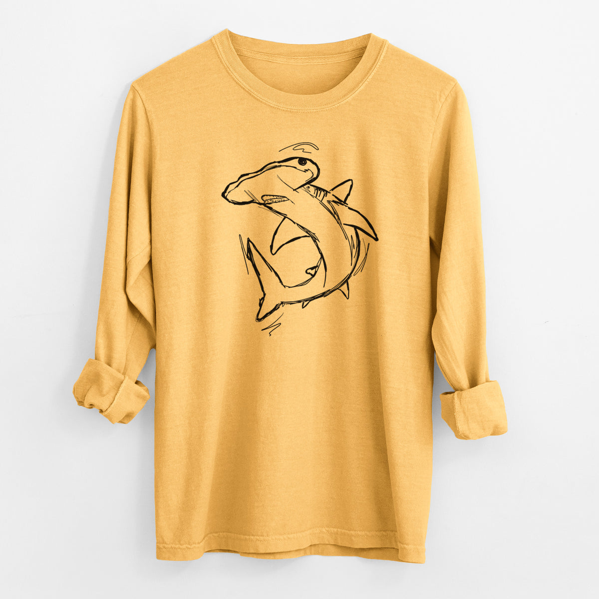 Golden wheat yellow Comfort Colors long sleeve shirt laid flat with the cuffs rolled, printed with a black ink illustration of a hammerhead shark swimming in a curve.