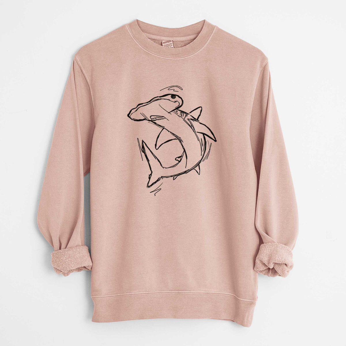 Dusty pink pigment dyed crewneck sweatshirt laid flat with the sleeves rolled, printed with a black ink illustration of a hammerhead shark swimming in a curve.