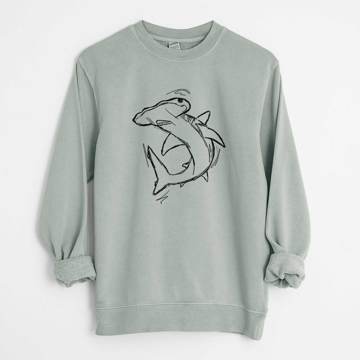 Sage green pigment dyed crewneck sweatshirt laid flat with the sleeves rolled, printed with a black ink illustration of a hammerhead shark swimming in a curve.