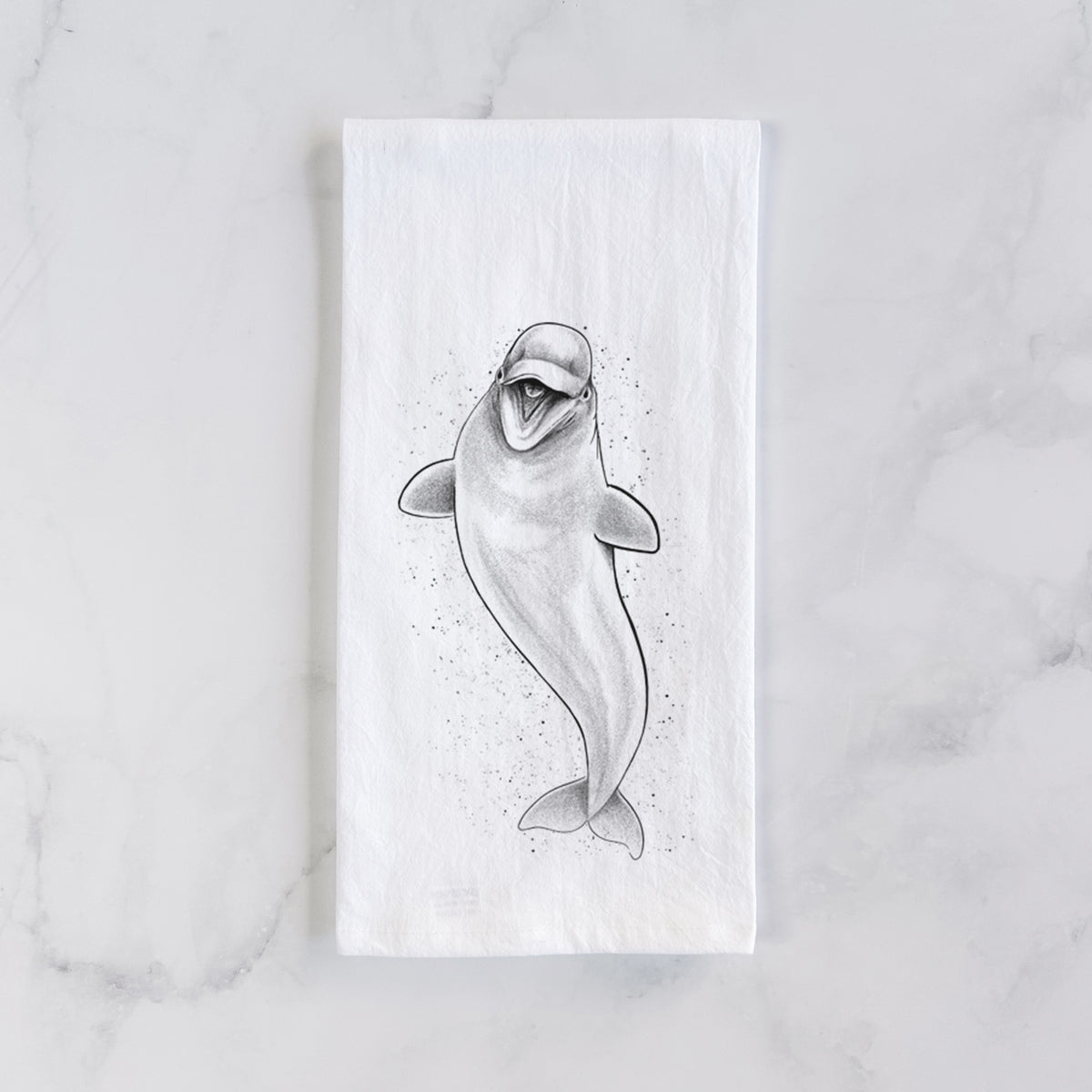White cotton tea towel laid flat on marble, printed with a black ink illustration of a smiling beluga whale swimming upward.