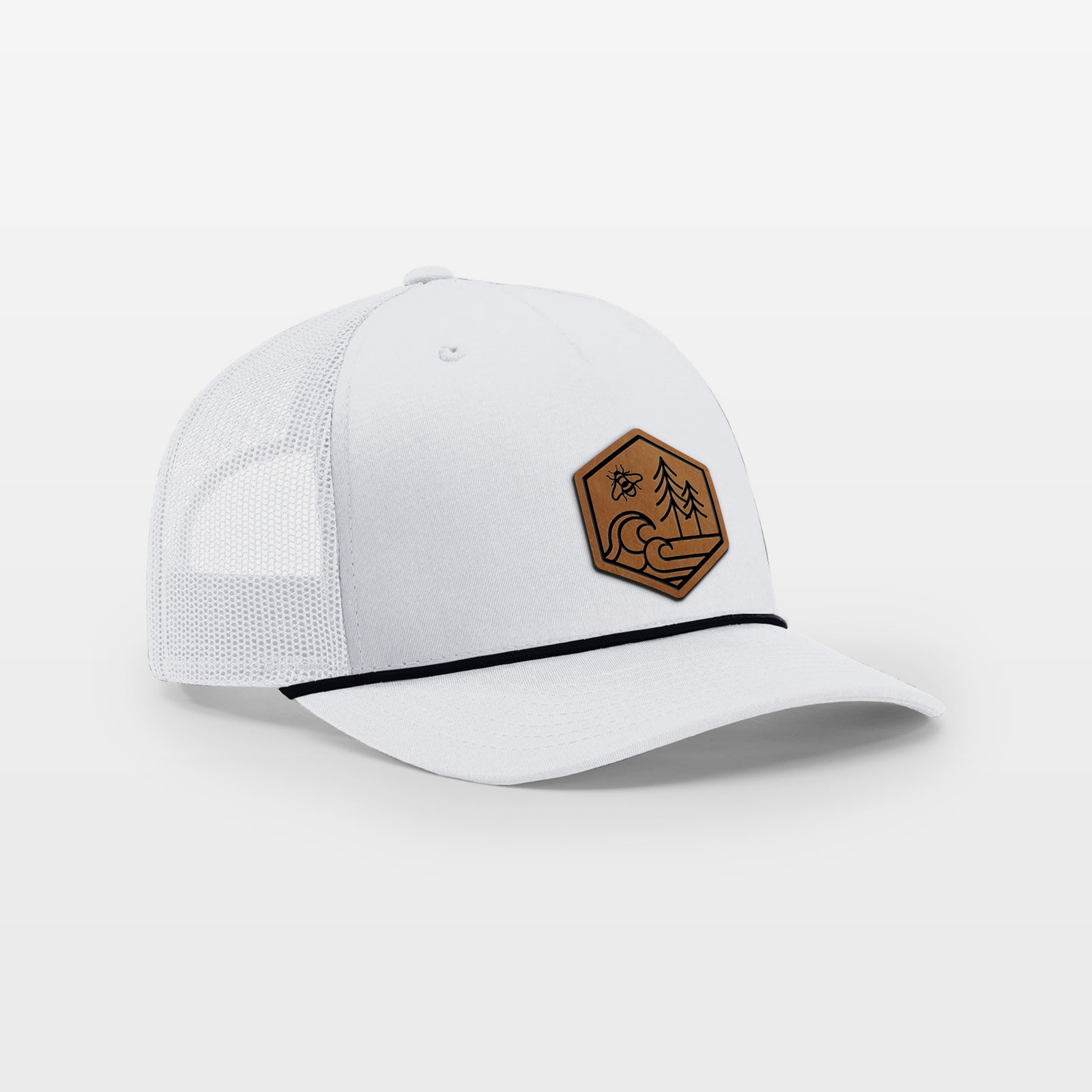 White and black rope trucker hat with a brown leather hexagon patch engraved with a bee, ocean waves and pine trees on the front.