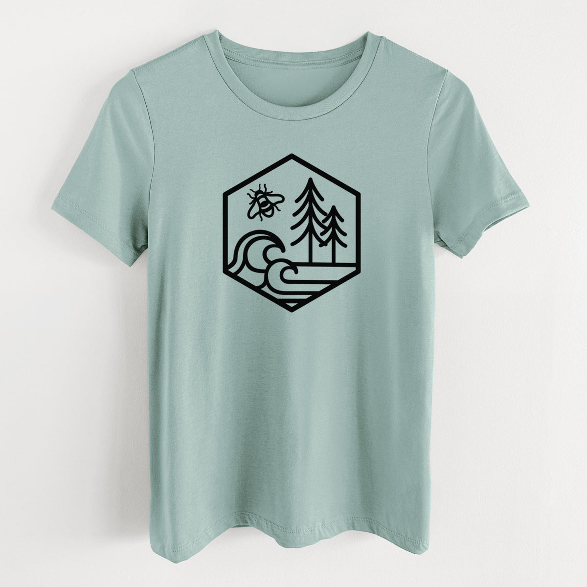 Dusty blue women's relaxed fit cotton t-shirt laid flat, printed with a black line art hexagon holding a bee, ocean waves and pine trees.