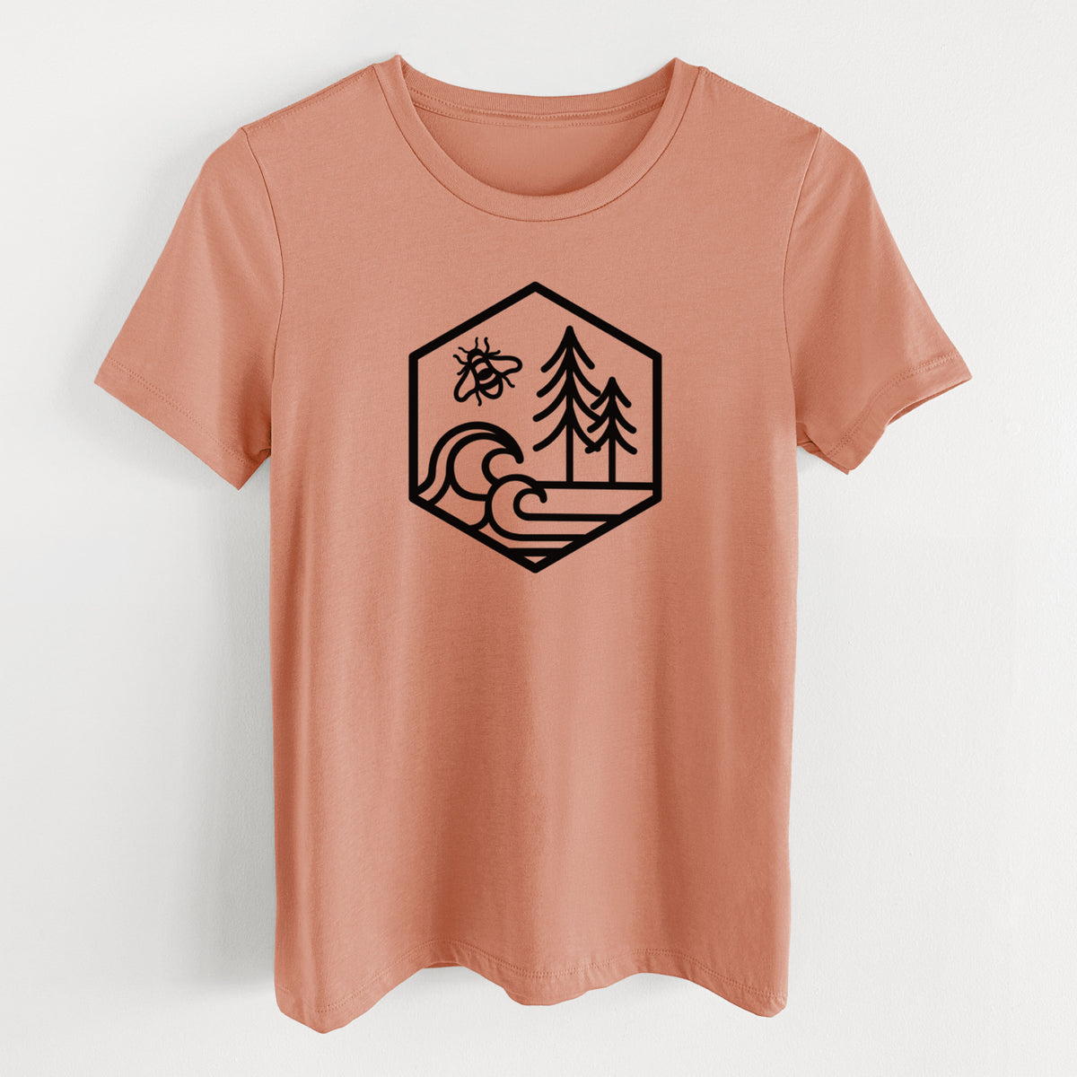 Terracotta orange women's relaxed fit cotton t-shirt laid flat, printed with a black line art hexagon holding a bee, ocean waves and pine trees.