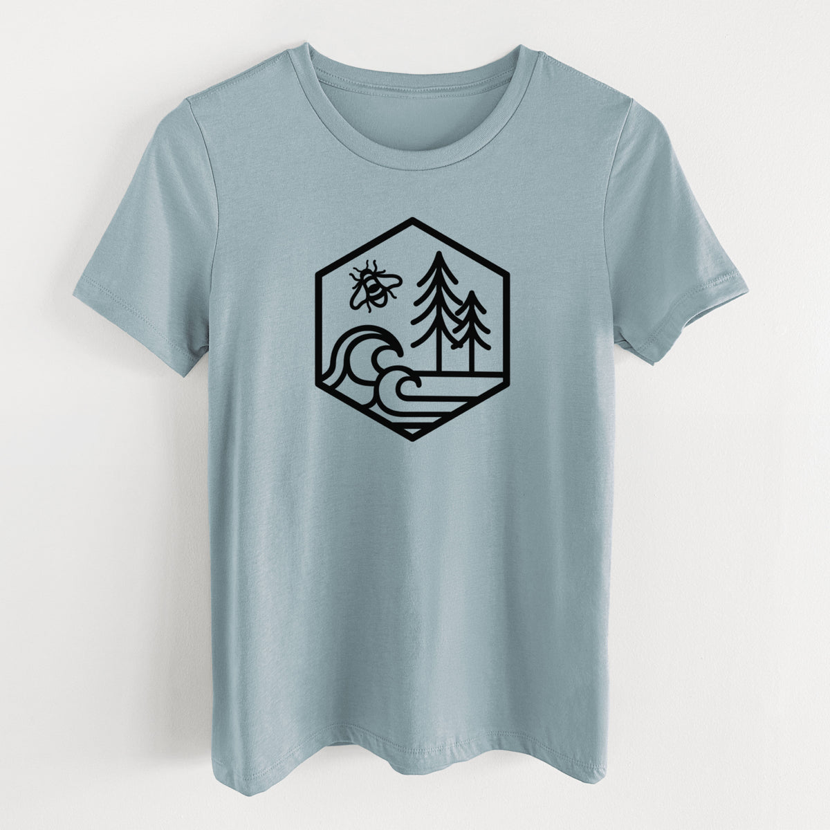 Vintage denim women's relaxed fit cotton t-shirt laid flat, printed with a black line art hexagon holding a bee, ocean waves and pine trees.