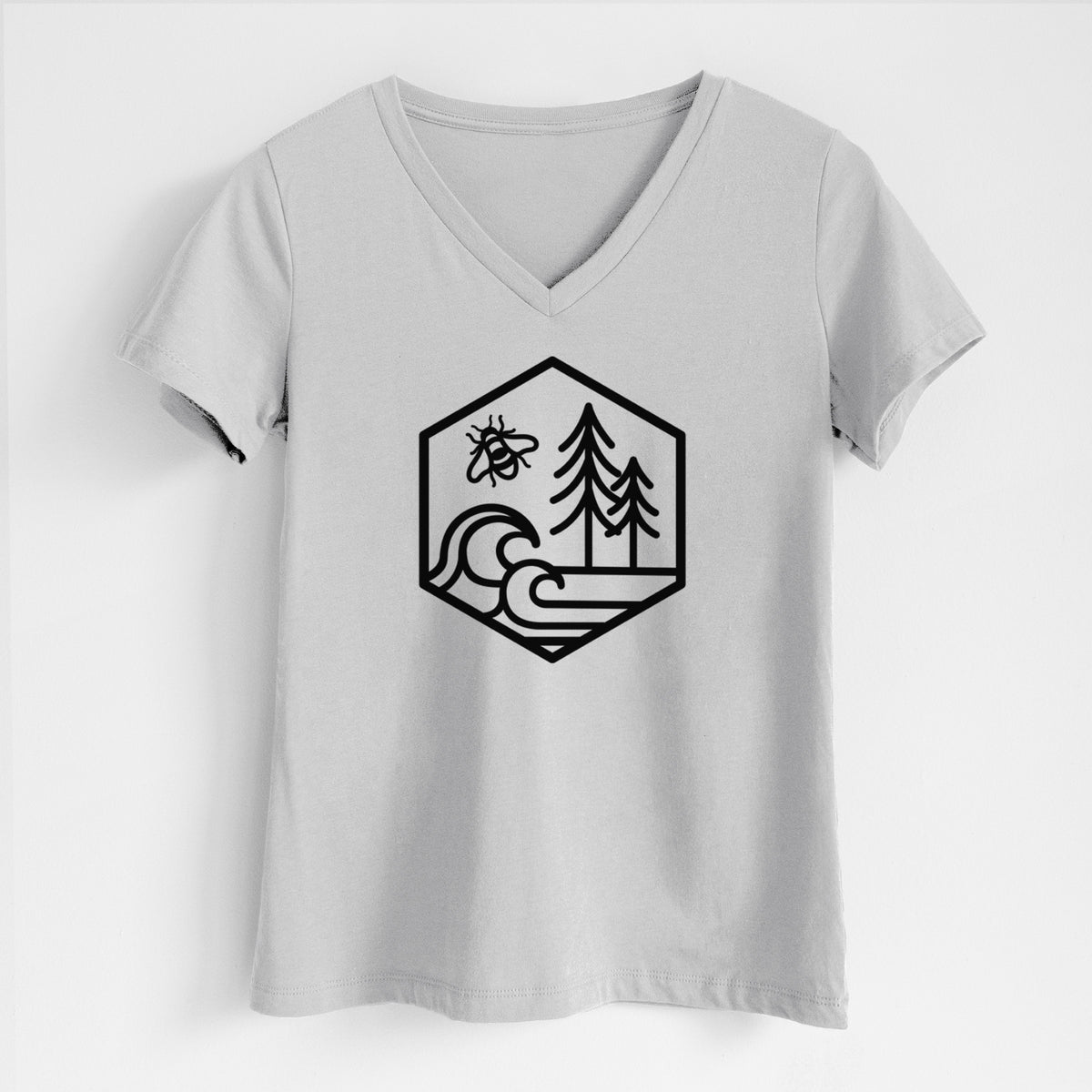 Lunar grey women's relaxed fit cotton V-neck t-shirt laid flat, printed with a black line art hexagon holding a bee, ocean waves and pine trees.