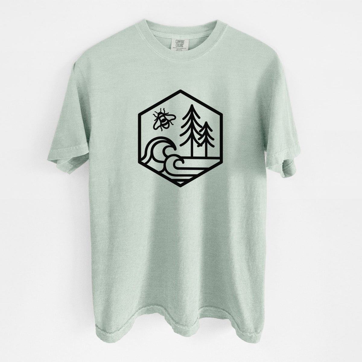 Bay green Comfort Colors t-shirt laid flat, printed with a black line art hexagon holding a bee, ocean waves and pine trees.