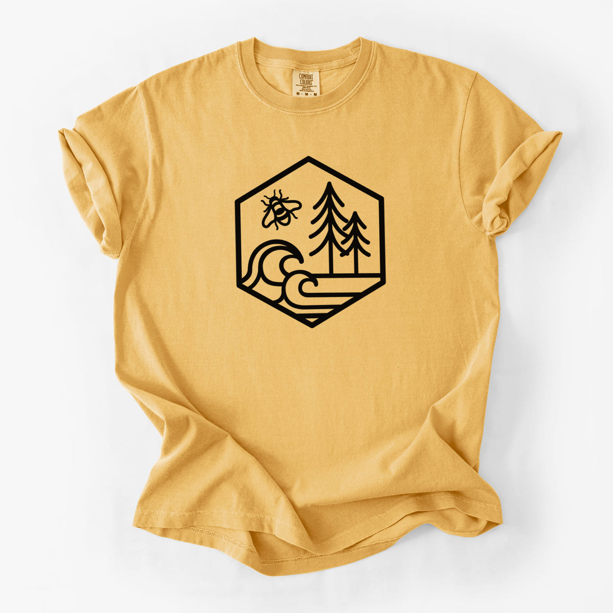 Golden wheat yellow Comfort Colors t-shirt laid flat, printed with a black line art hexagon holding a bee, ocean waves and pine trees.