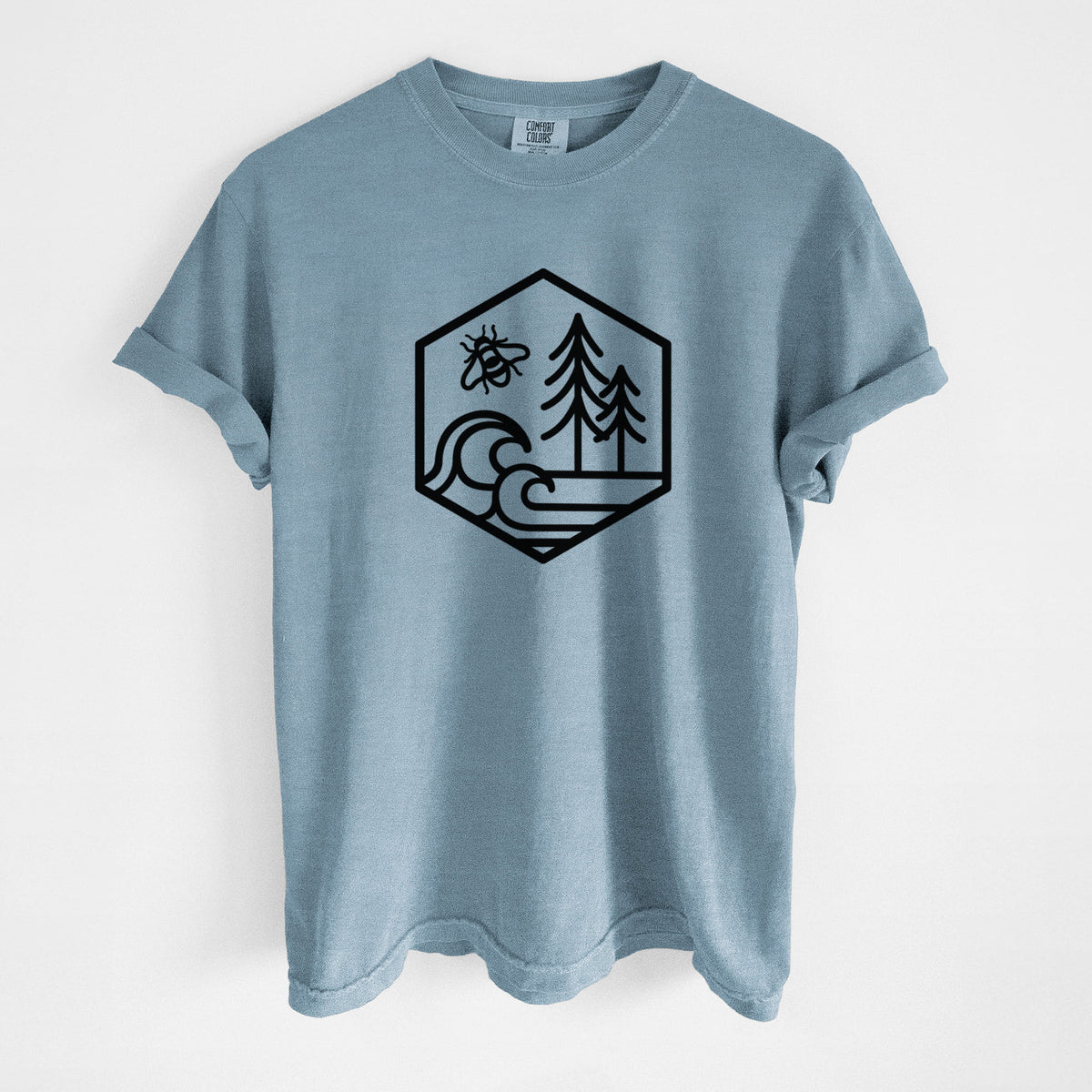 Steel blue Comfort Colors t-shirt laid flat, printed with a black line art hexagon holding a bee, ocean waves and pine trees.