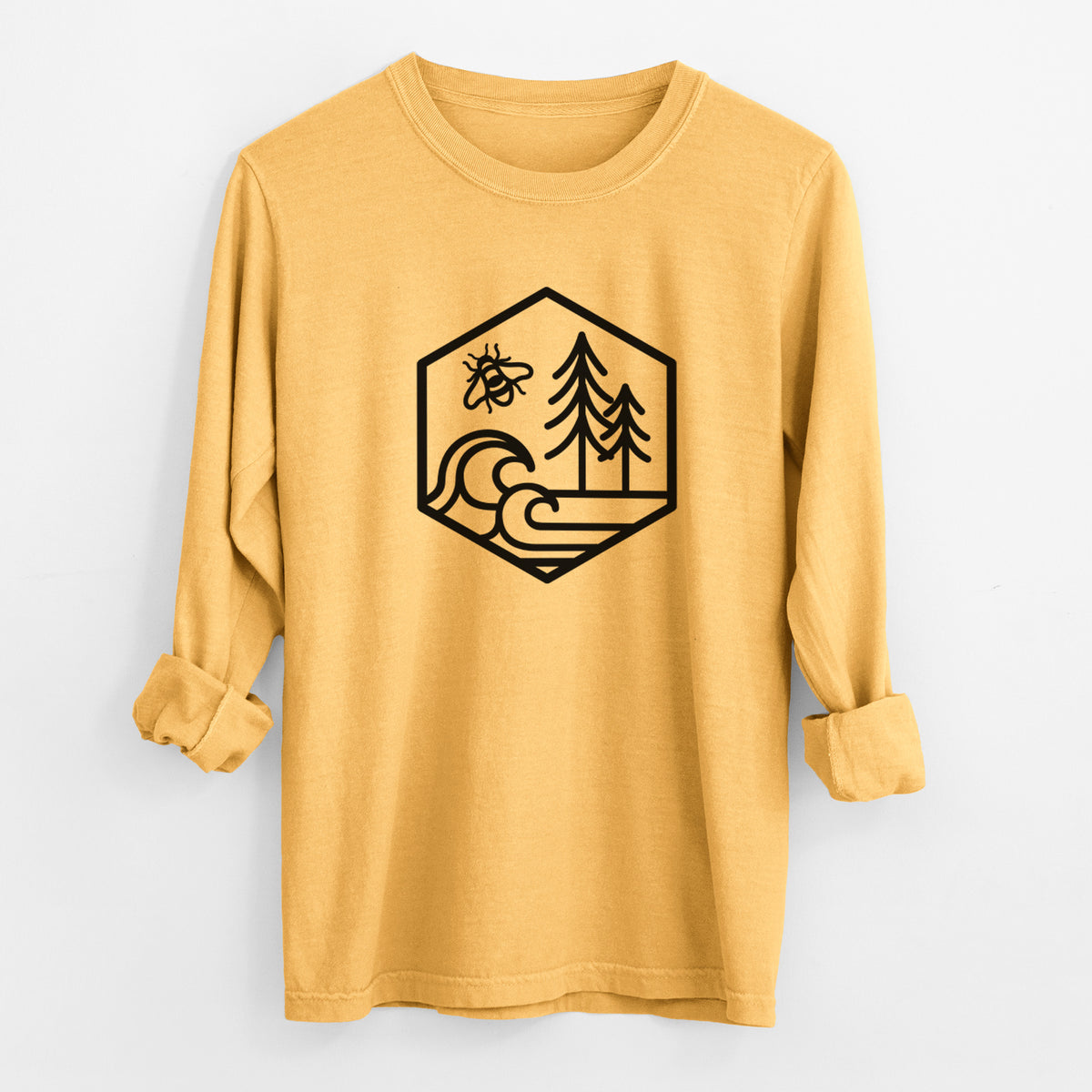 Golden wheat yellow Comfort Colors long sleeve shirt laid flat with the cuffs rolled, printed with a black line art hexagon holding a bee, ocean waves and pine trees.