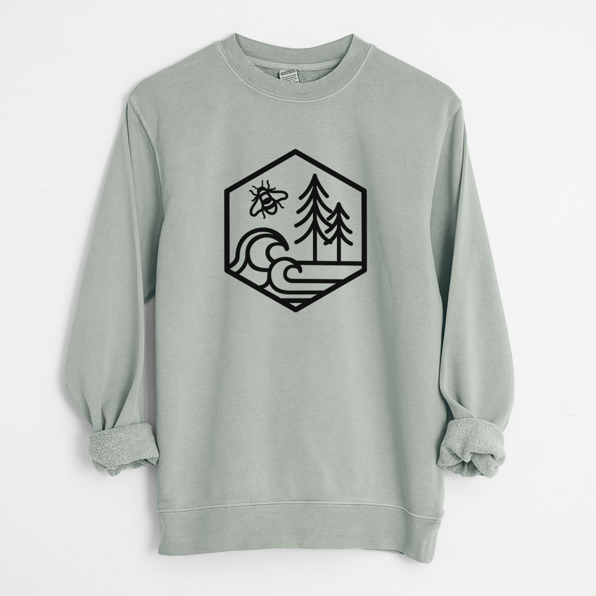 Sage green pigment dyed crewneck sweatshirt laid flat with the sleeves rolled, printed with a black line art hexagon holding a bee, ocean waves and pine trees.