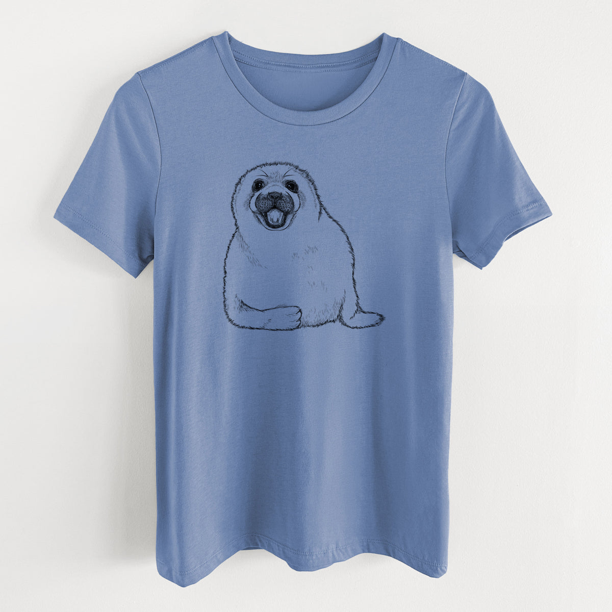 Blue bell women's relaxed fit cotton t-shirt laid flat, printed with a black ink illustration of a smiling harp seal pup lying down.