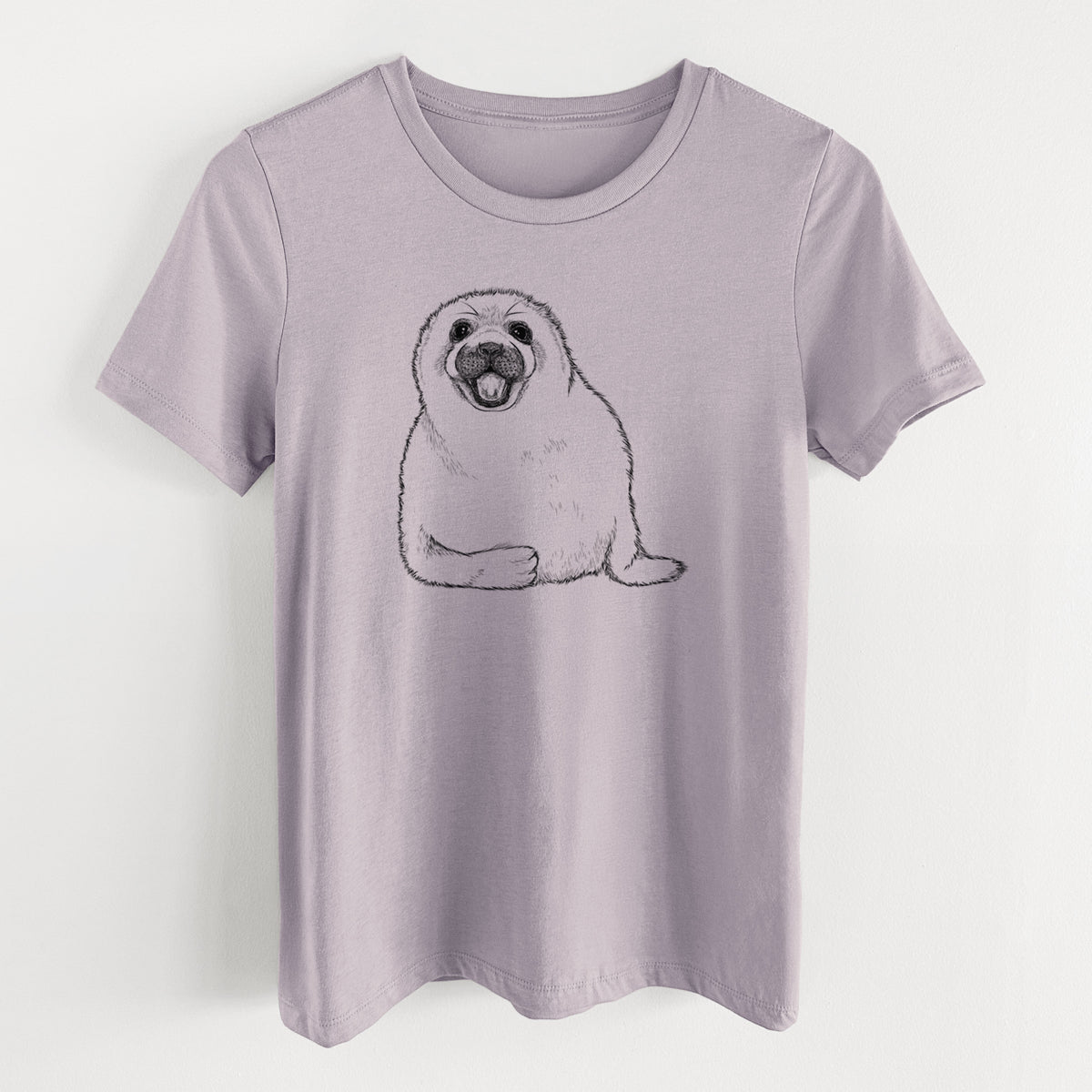 Light violet women's relaxed fit cotton t-shirt laid flat, printed with a black ink illustration of a smiling harp seal pup lying down.