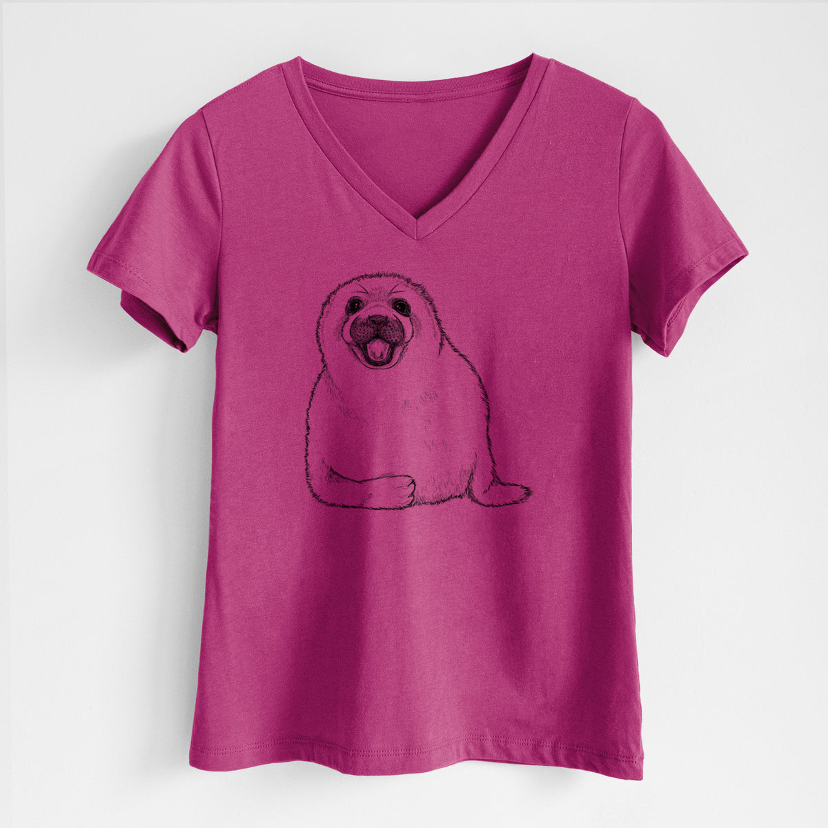 Berry pink women's relaxed fit cotton V-neck t-shirt laid flat, printed with a black ink illustration of a smiling harp seal pup lying down.