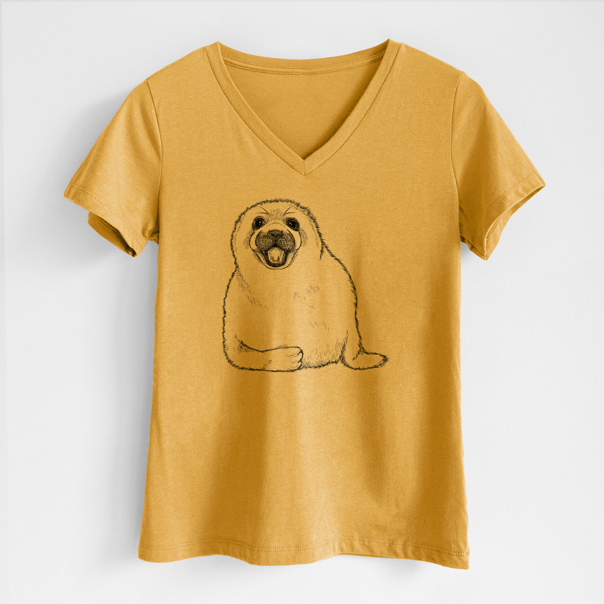 Honeycomb yellow women's relaxed fit cotton V-neck t-shirt laid flat, printed with a black ink illustration of a smiling harp seal pup lying down.