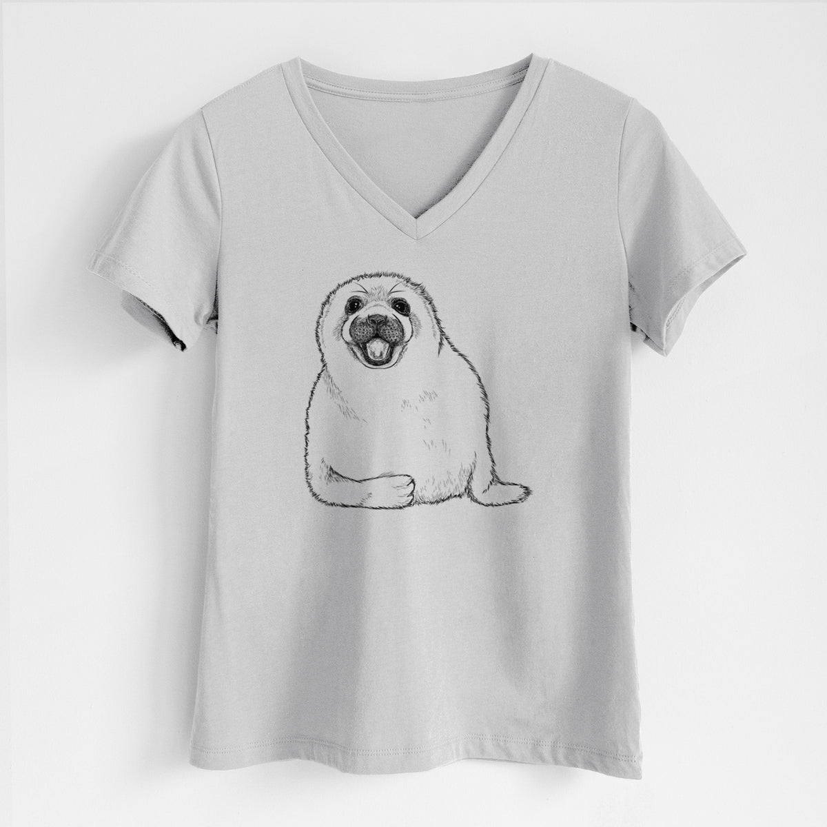 Lunar grey women's relaxed fit cotton V-neck t-shirt laid flat, printed with a black ink illustration of a smiling harp seal pup lying down.