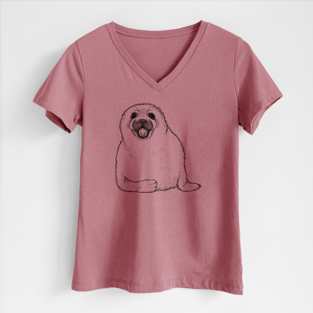 Mauve pink women's relaxed fit cotton V-neck t-shirt laid flat, printed with a black ink illustration of a smiling harp seal pup lying down.
