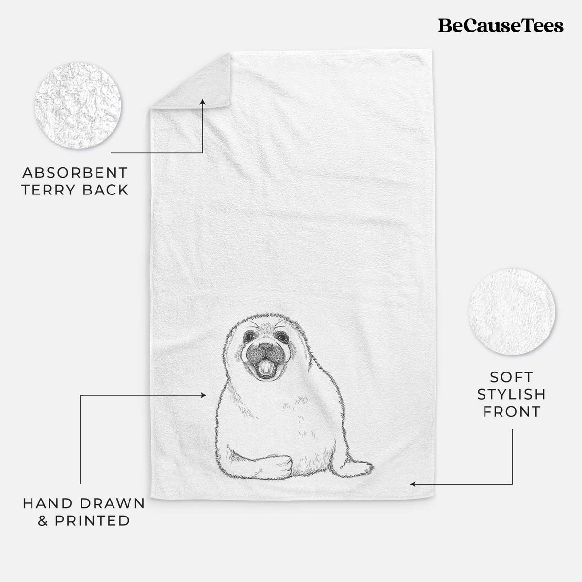 White hand towel printed with a black ink illustration of a smiling harp seal pup lying down.