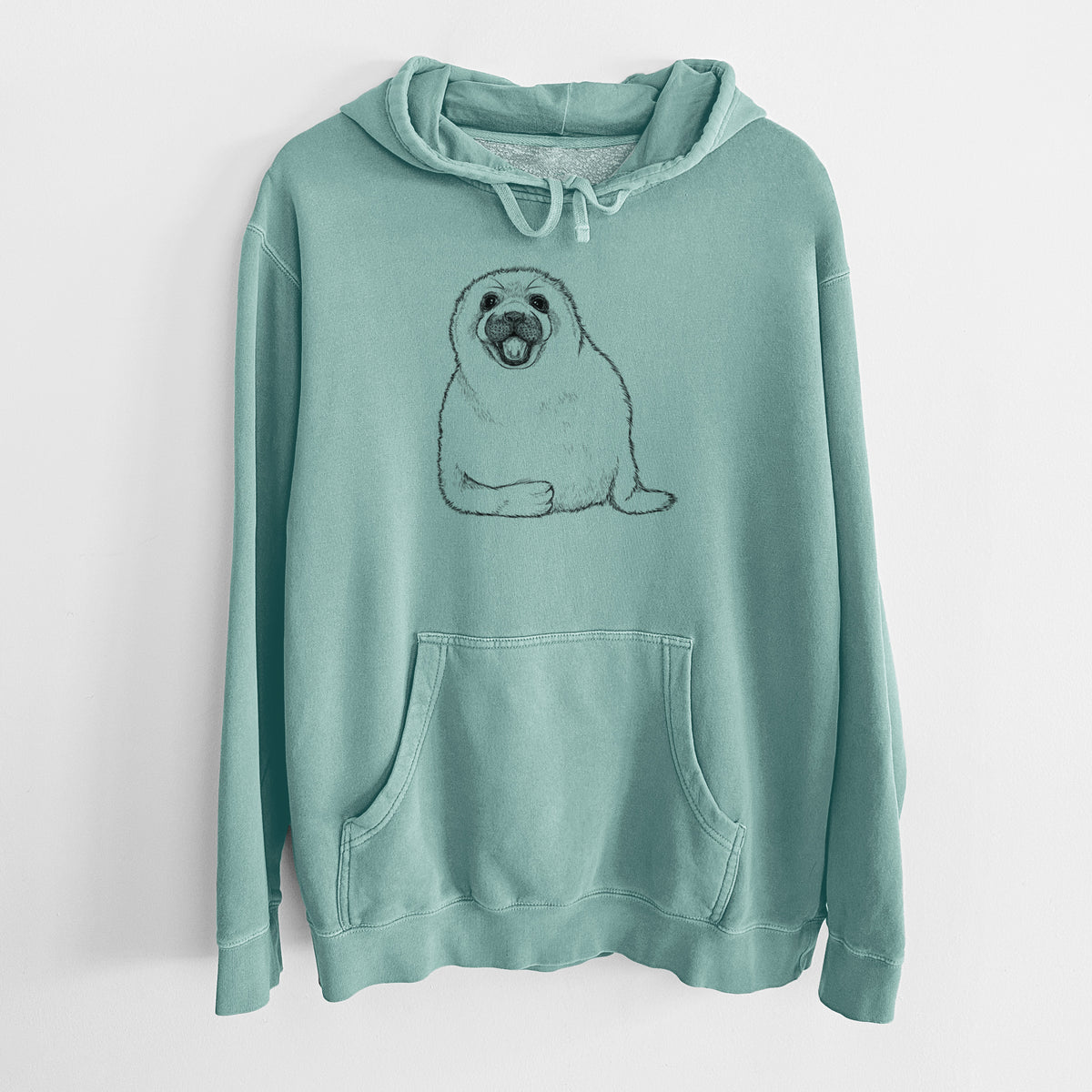 Mint green pigment dyed hoodie laid flat, printed with a black ink illustration of a smiling harp seal pup lying down.